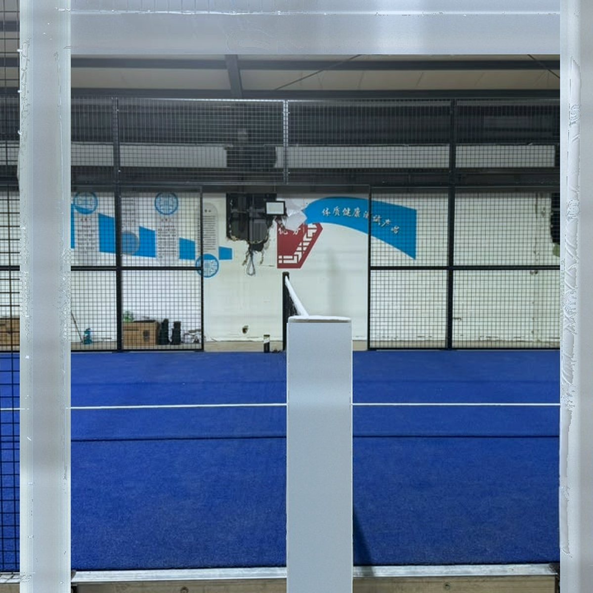 Schutzpolsterungen an Türrahmen und Netzpfosten eines Padel Courts